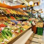 People shopping in produce aisle of grocery store